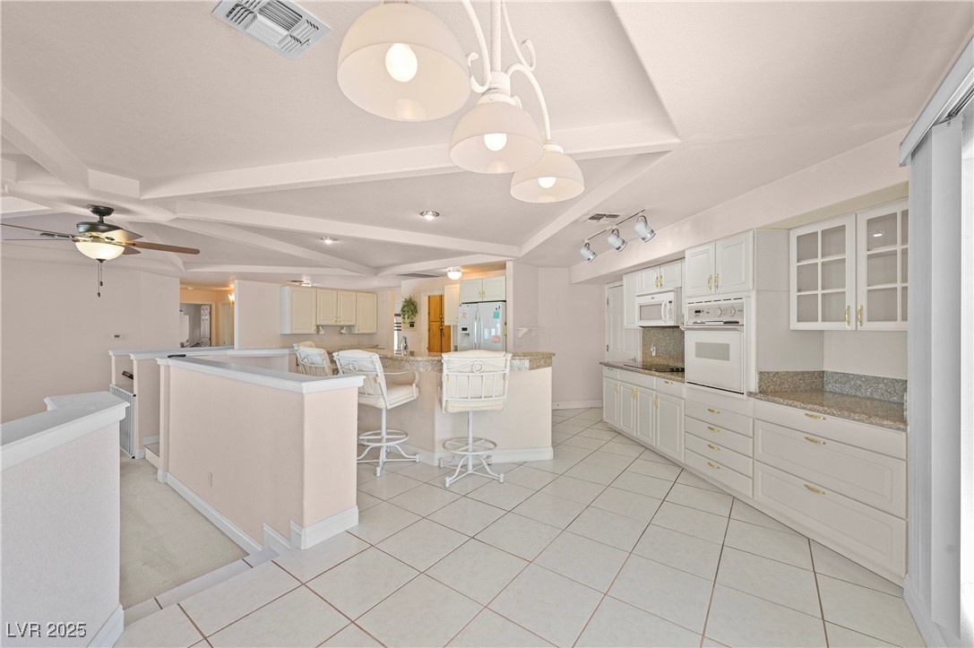 736 Kiel Street Henderson, NV 89015 - Photo 13 of 38 Kitchen with white appliances, light tile patterned floors, visible vents, and light countertops