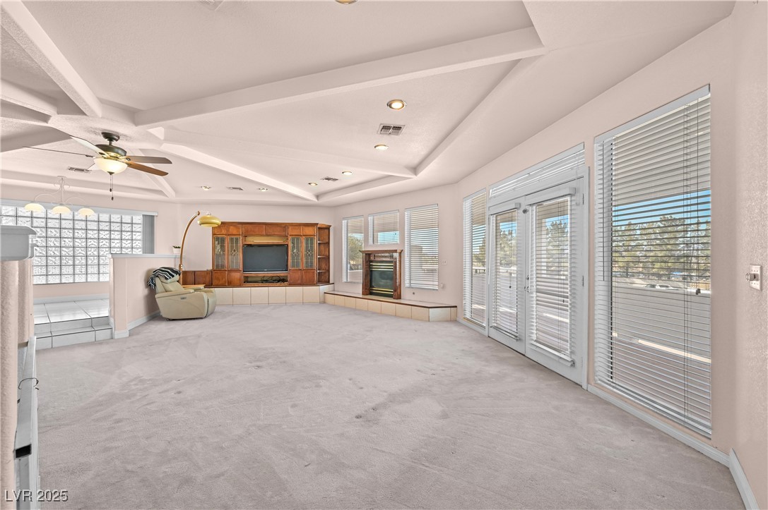 736 Kiel Street Henderson, NV 89015 - Photo 9 of 38 Unfurnished living room with light colored carpet, a tile fireplace, a wealth of natural light, and visible vents