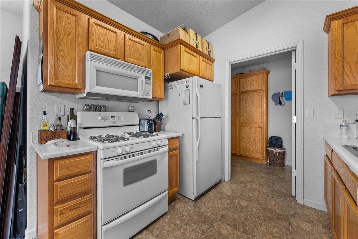 732 Stonebriar Trail Redding, CA 96003 - Photo 13 of 29 a kitchen with white cabinets and white appliances