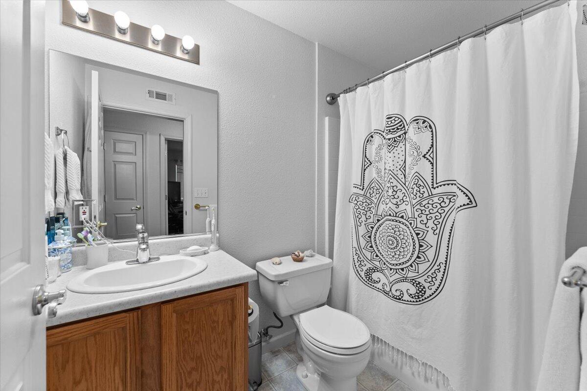 732 Stonebriar Trail Redding, CA 96003 - Photo 22 of 29 a bathroom with a granite countertop sink a toilet and a mirror