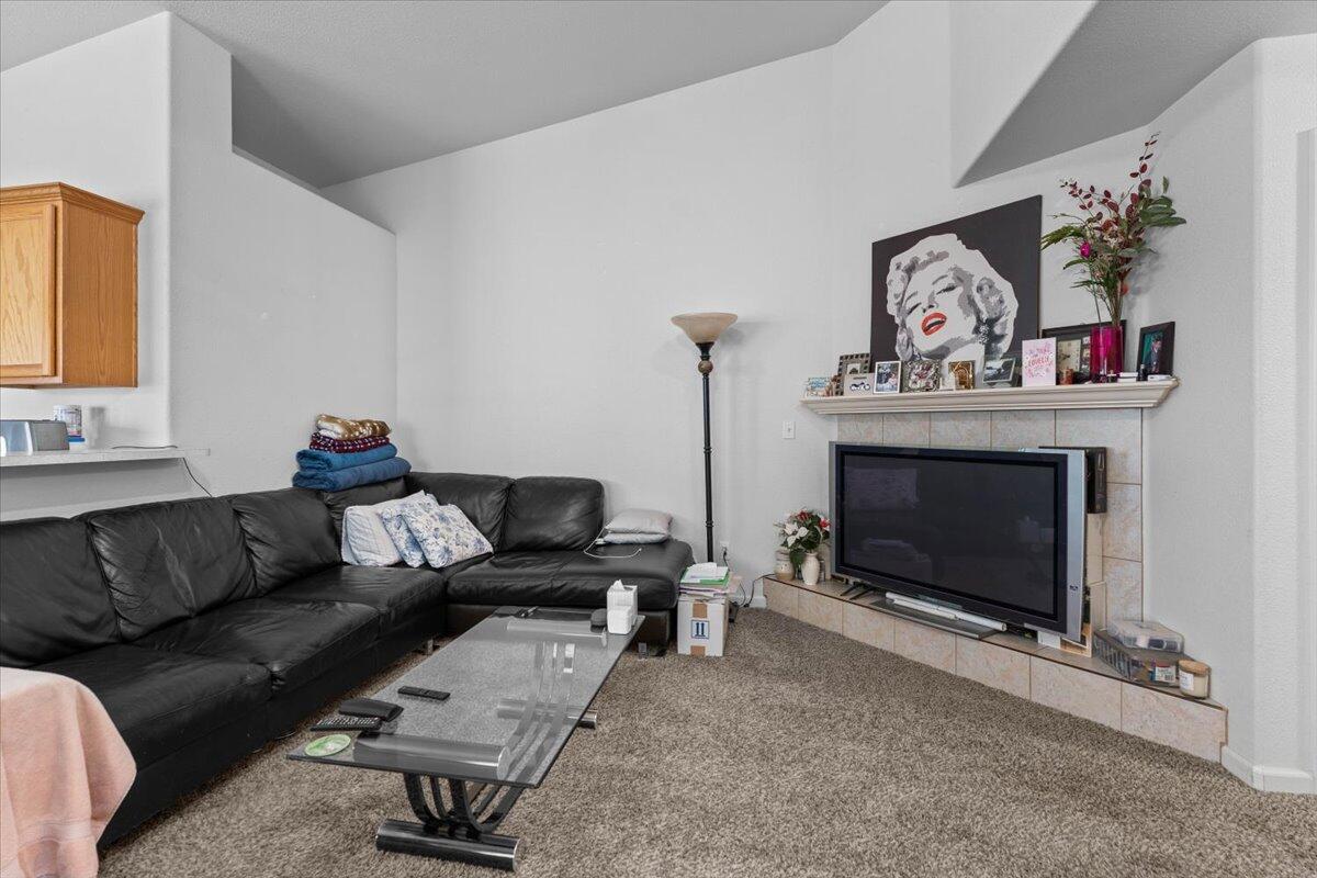 732 Stonebriar Trail Redding, CA 96003 - Photo 8 of 29 a living room with furniture a flat screen tv and a fireplace