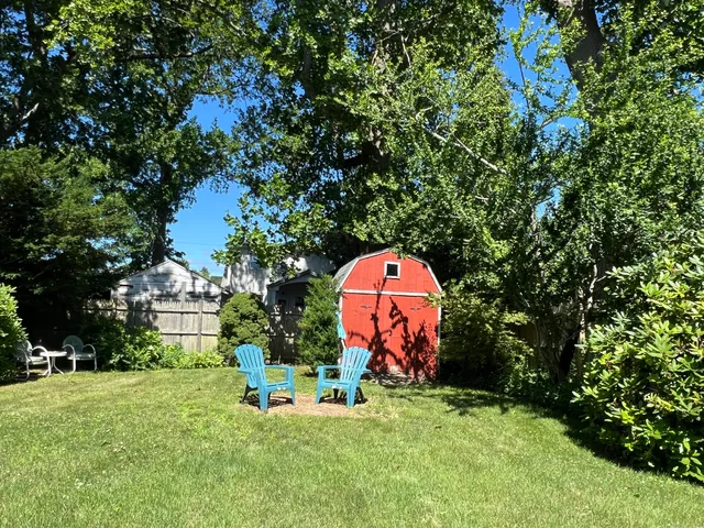 a kitchen with stainless steel appliances granite countertop a stove a refrigerator a sink a dining table and chairs with wooden floor