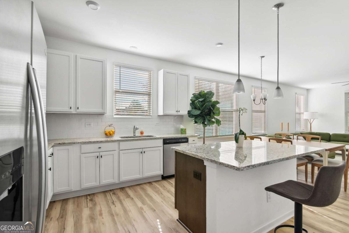 1453 Proust Lane, Unit 1453 Stockbridge, GA 30281 - Photo 7 of 26 a large kitchen with granite countertop a sink and cabinets