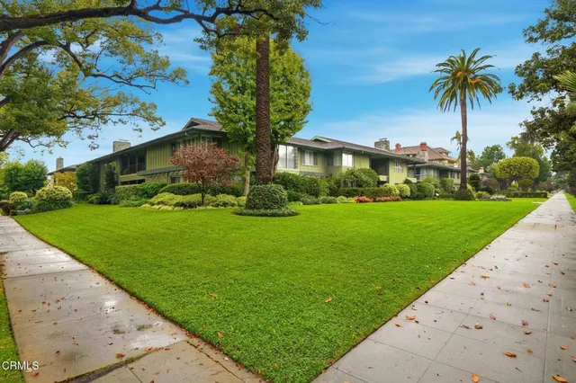 a front view of a house with a yard and palm trees