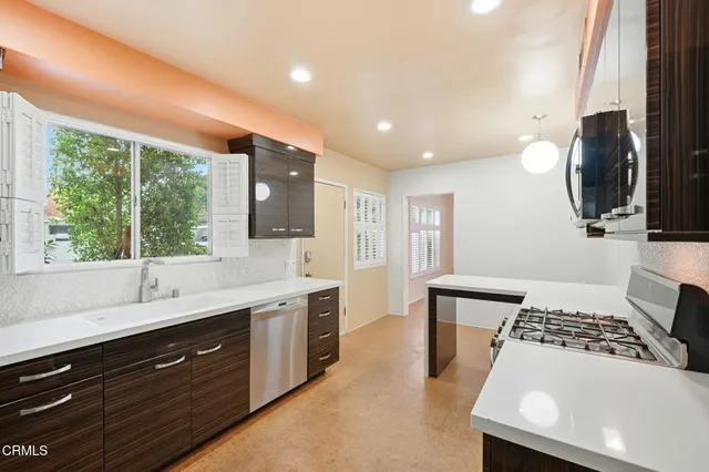 a kitchen with a sink a window and stainless steel appliances