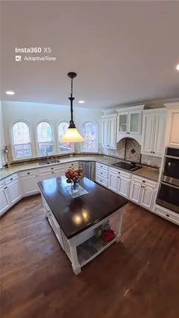 a kitchen with granite countertop a stove and cabinets