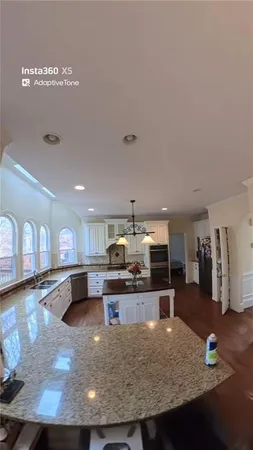 a large kitchen with stainless steel appliances granite countertop a large counter top and a stove