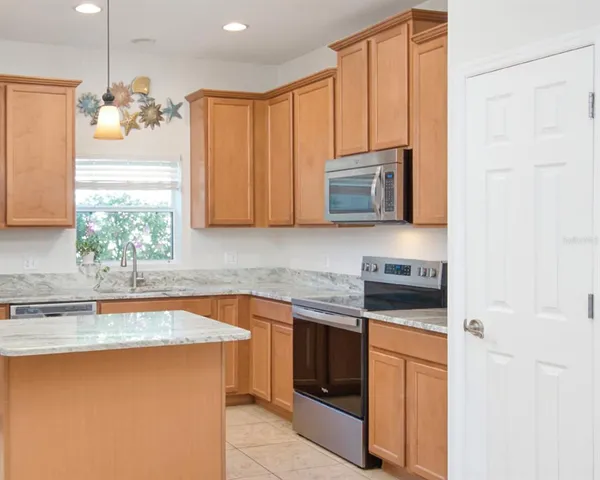 a kitchen with stainless steel appliances granite countertop a sink stove and microwave