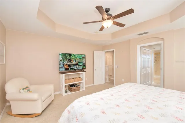 a bedroom with a bed a couch and a chandelier