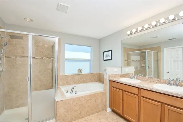 a bathroom with a granite countertop sink mirror bathtub and shower