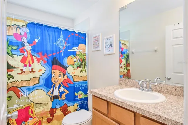 a bathroom with a sink mirror vanity and toilet