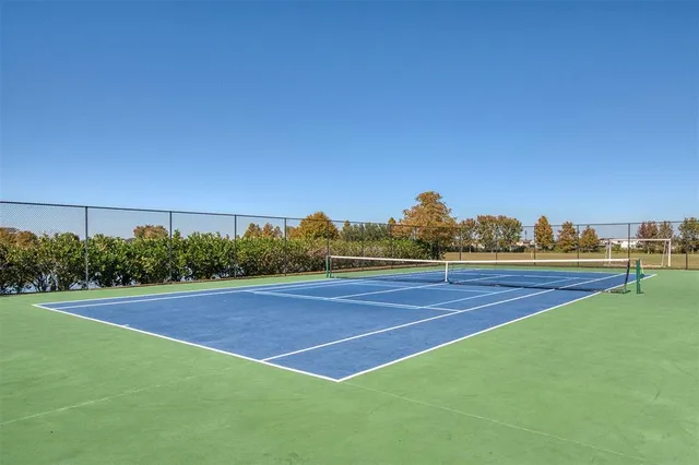 a view of swimming pool with seating space and trees in the background