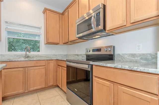 a kitchen with stainless steel appliances granite countertop a sink and a microwave
