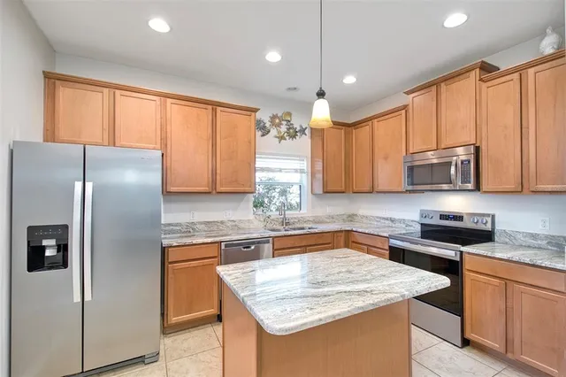a kitchen with stainless steel appliances granite countertop refrigerator sink and microwave