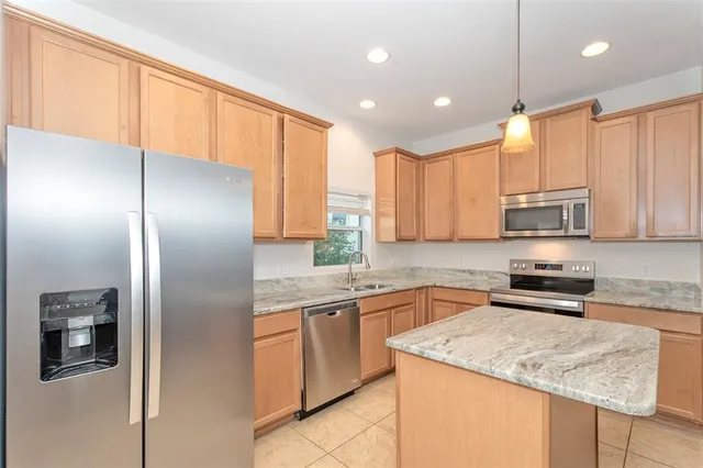 a kitchen with stainless steel appliances granite countertop a refrigerator sink and cabinets