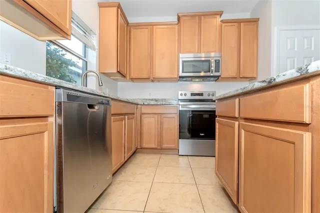 a kitchen with stainless steel appliances granite countertop a refrigerator and a stove