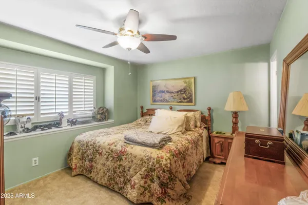 a spacious bedroom with a bed and a chandelier