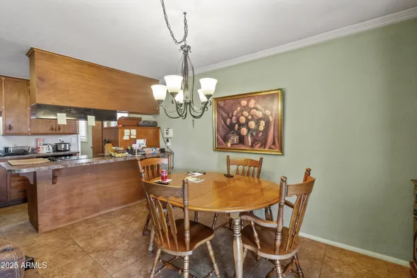 a view of a dining room with furniture a chandelier and wooden floor