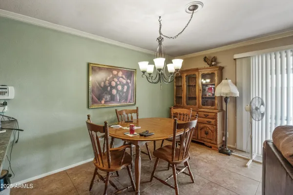 a view of a dining room with furniture a chandelier and wooden floor