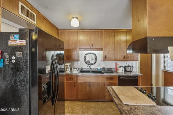 a kitchen with a sink a refrigerator and cabinets