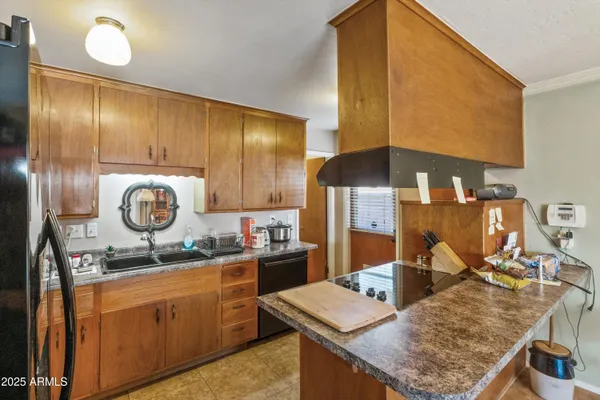 a kitchen with kitchen island granite countertop a sink stove and cabinets