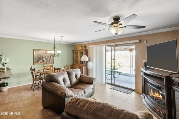a living room with furniture a ceiling fan and a window