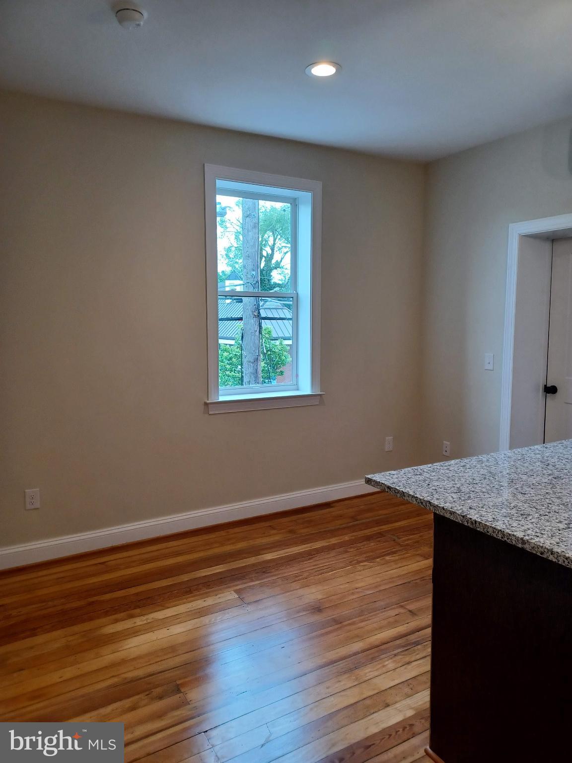 903 South Loudoun Street, Unit 1 Winchester, VA 22601 - Photo 2 of 8 a view of an empty room with wooden floor and a window