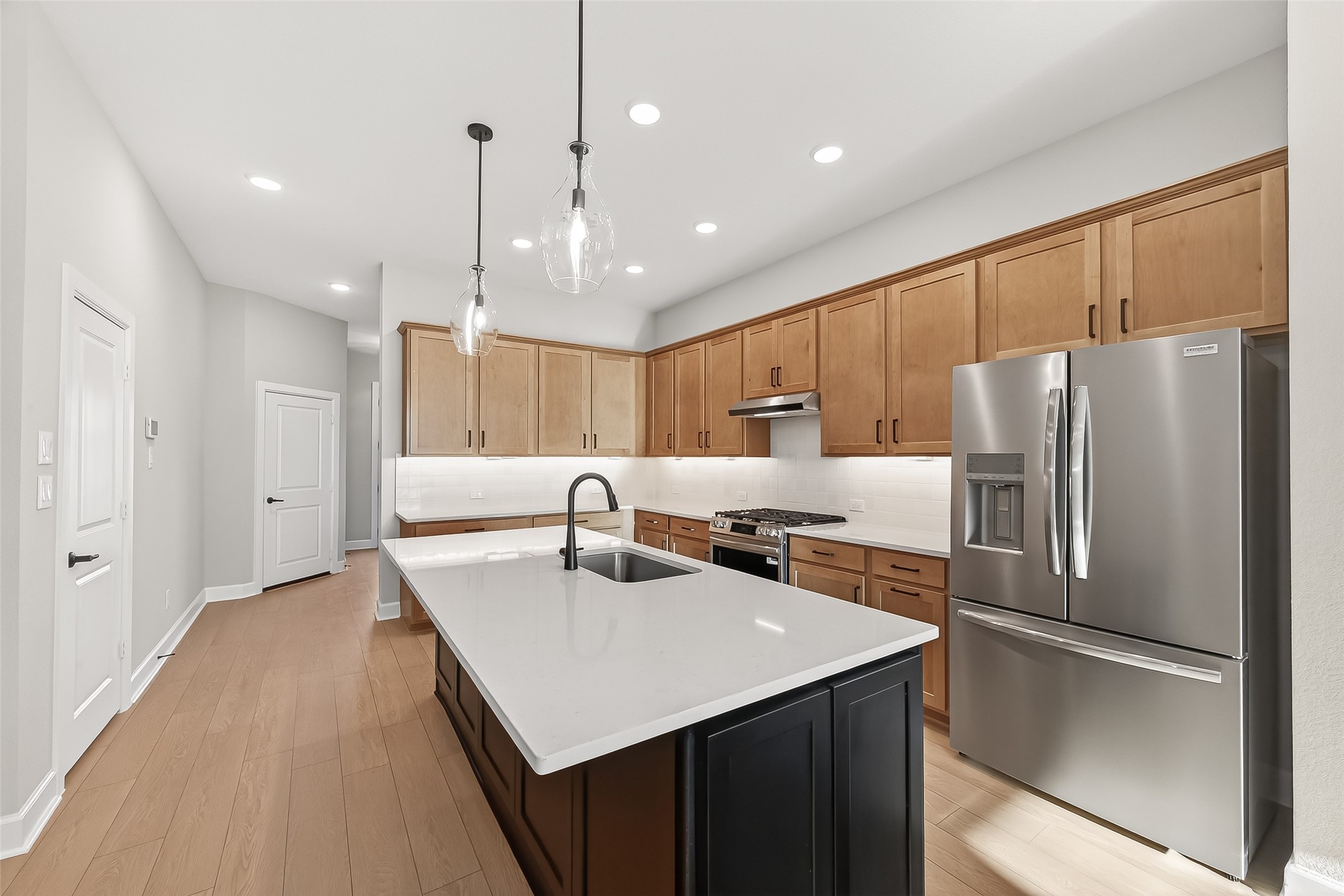 11219 Peacock Flower Street Cypress, TX 77433 - Photo 1 of 50 a kitchen with kitchen island a refrigerator a sink and a stove