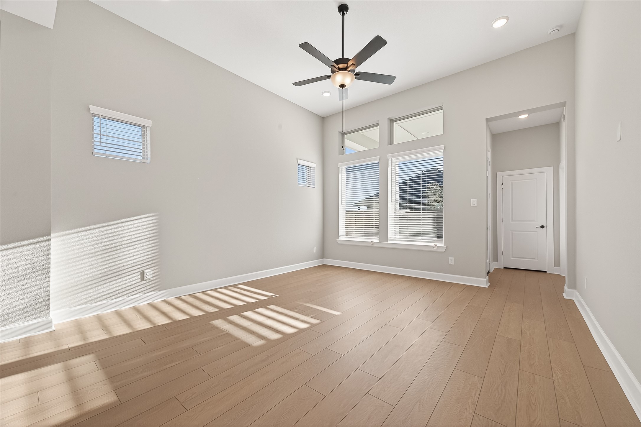 11219 Peacock Flower Street Cypress, TX 77433 - Photo 13 of 50 a view of an empty room with a window and wooden floor