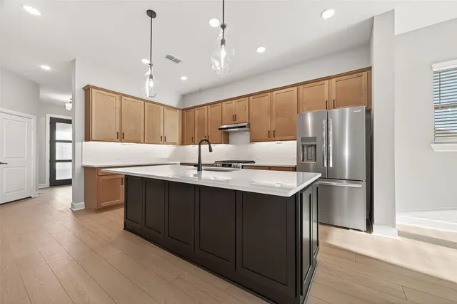 a kitchen with kitchen island granite countertop wooden cabinets and white appliances