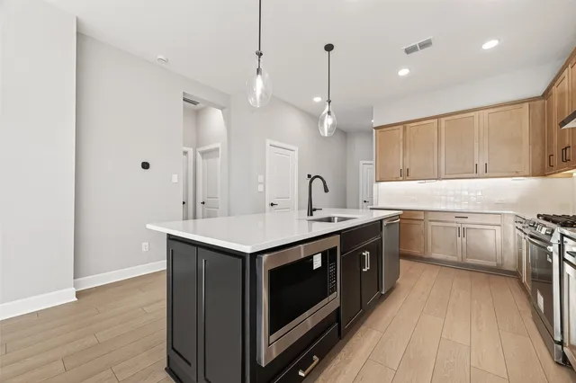 a kitchen with a sink stove and wooden floor