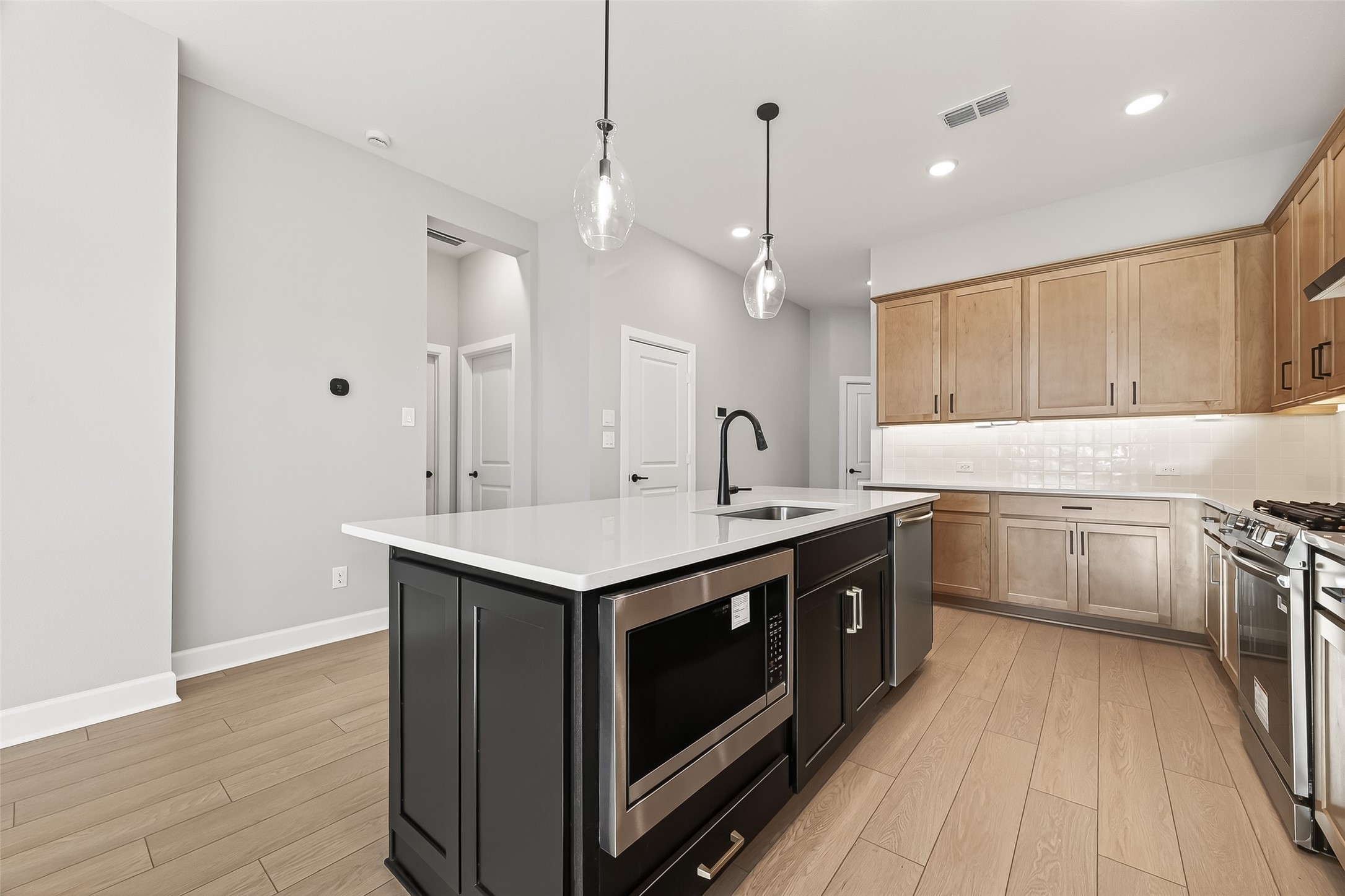 11219 Peacock Flower Street Cypress, TX 77433 - Photo 2 of 50 a kitchen with a sink stove and wooden floor