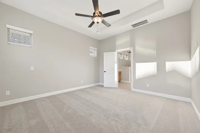 a view of an empty room and a ceiling fan window
