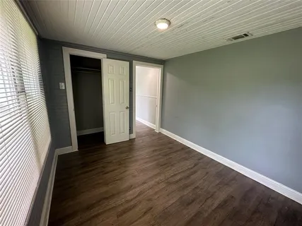 a hallway with front door wooden floor and cabinet