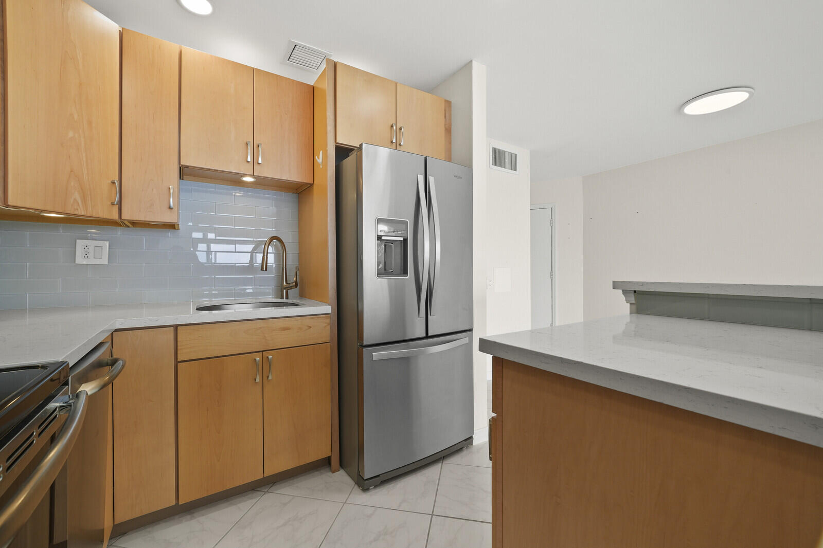 400 Wilma Circle, Unit 207 Riviera Beach, FL 33404 - Photo 11 of 26 a kitchen with stainless steel appliances granite countertop a refrigerator a sink and white cabinets