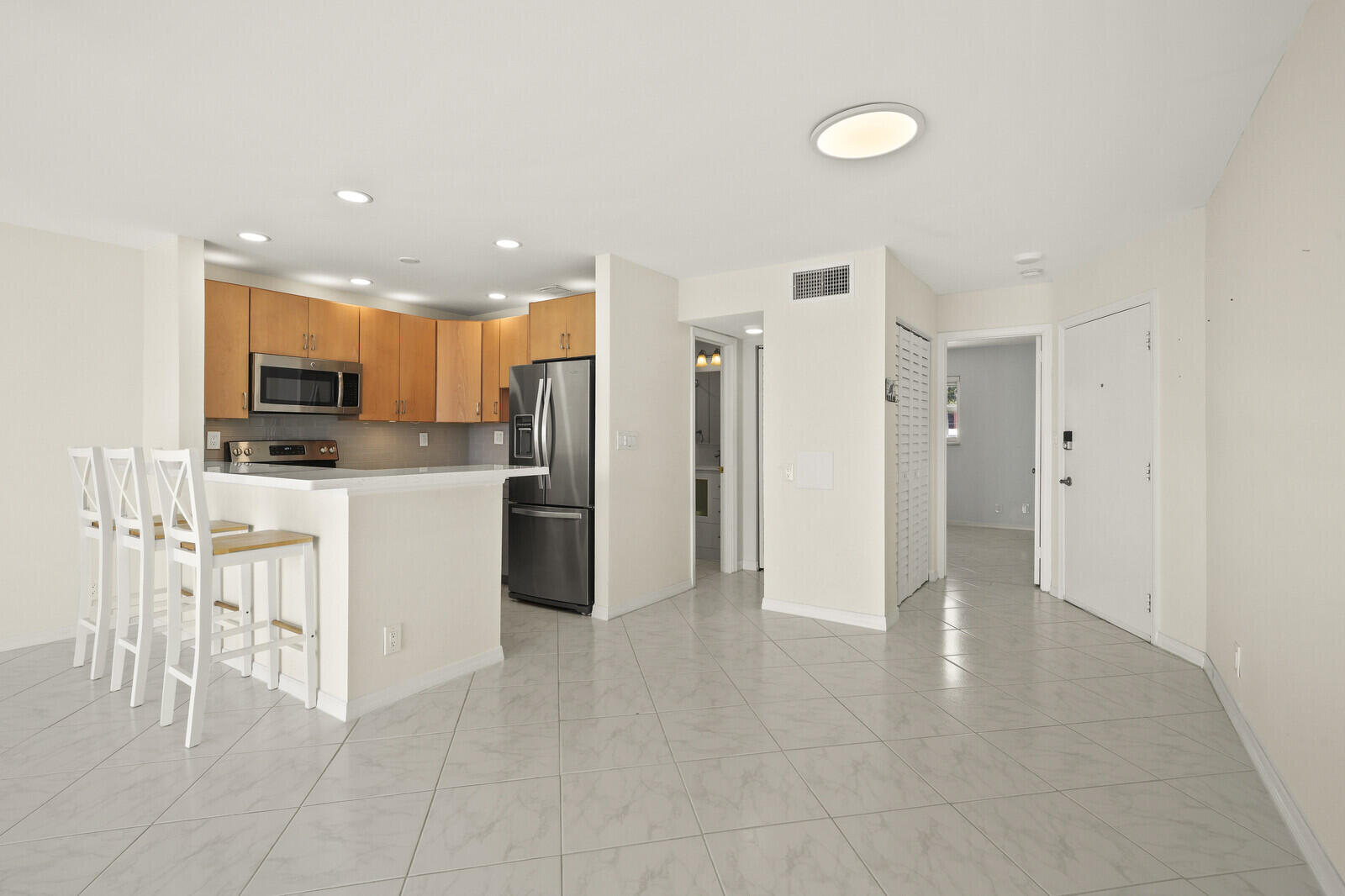 400 Wilma Circle, Unit 207 Riviera Beach, FL 33404 - Photo 6 of 26 a view of kitchen with stainless steel appliances kitchen island refrigerator stove microwave and cabinets