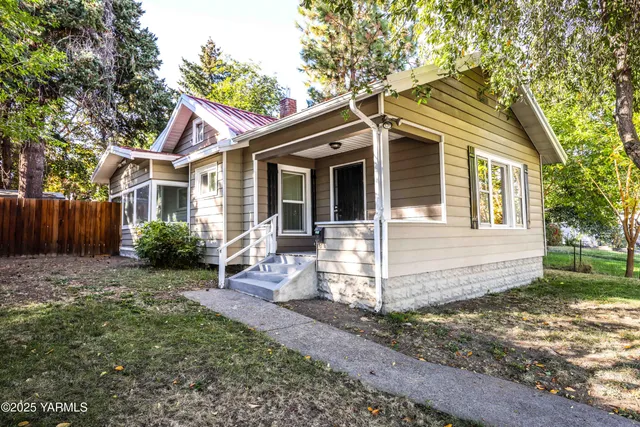 a view of a house with a yard and wooden fence