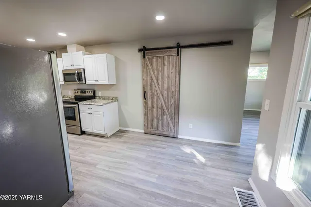 a view of kitchen with wooden floor electronic appliances and sink