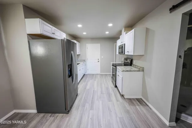 a view of a kitchen with wooden floor and electronic appliances