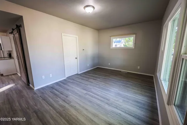 an empty room with wooden floor and a window