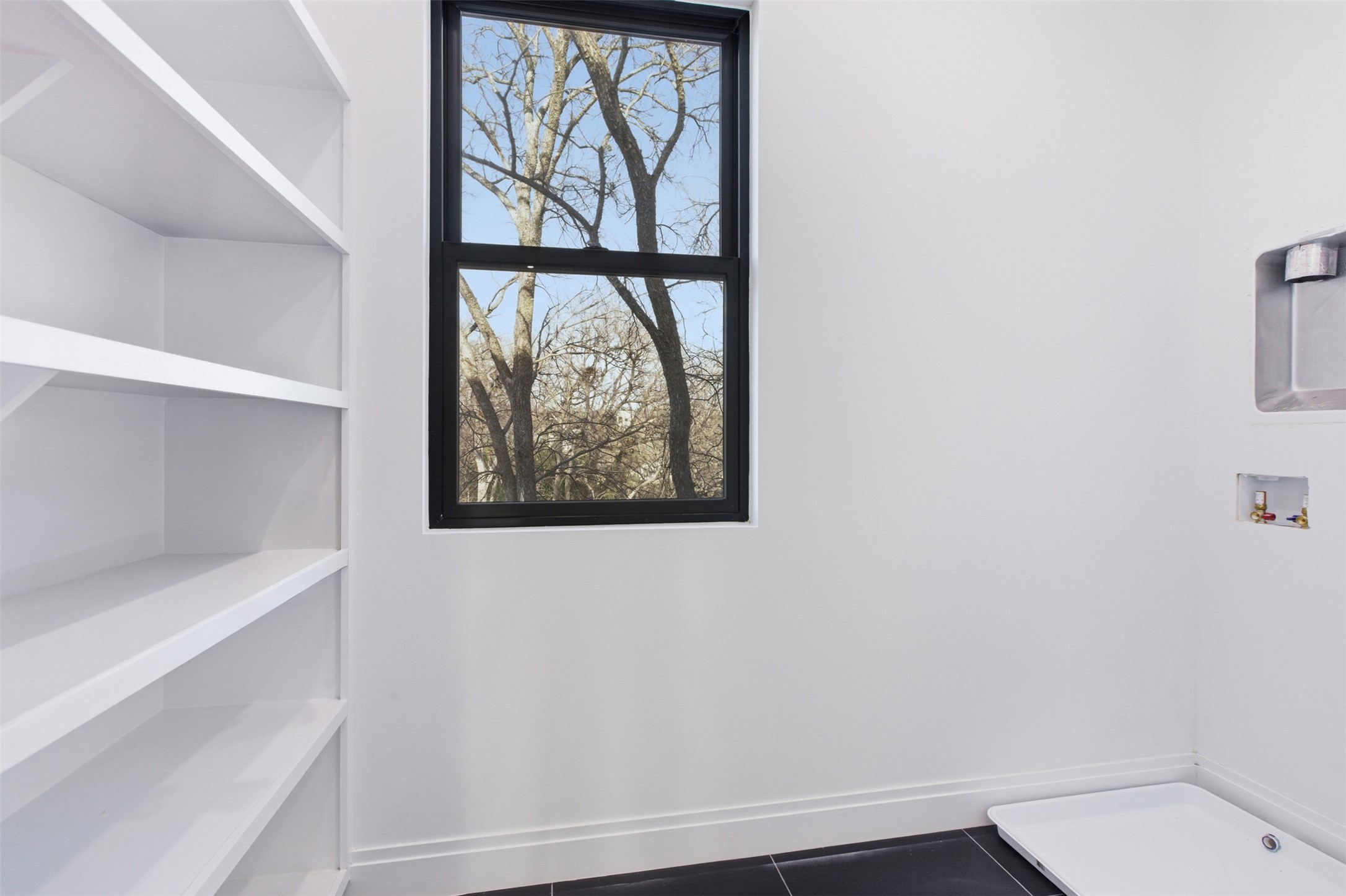 5013 Rob-Scott Street Austin, TX 78721 - Photo 13 of 35 Utility Room with shelving and natural lighting.