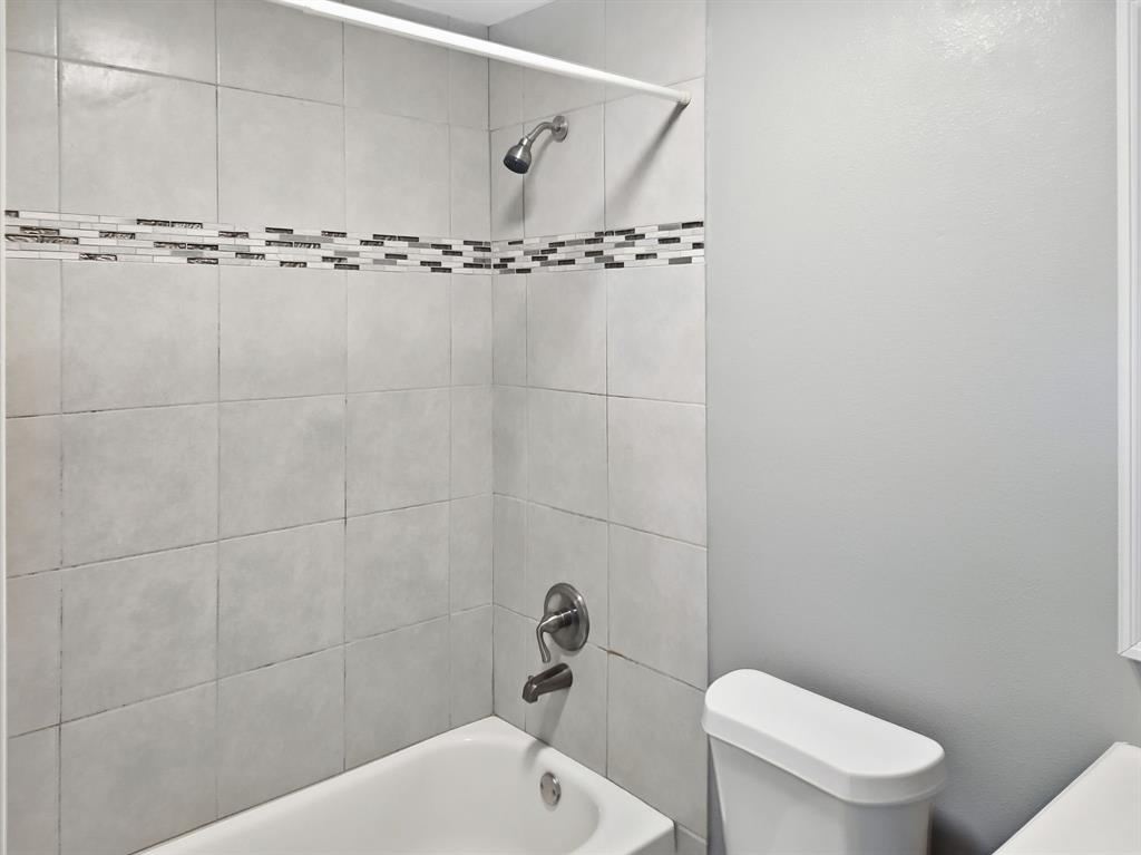 110 Ramsey Street Cleburne, TX 76031 - Photo 13 of 27 a bathroom with a toilet and a bathtub