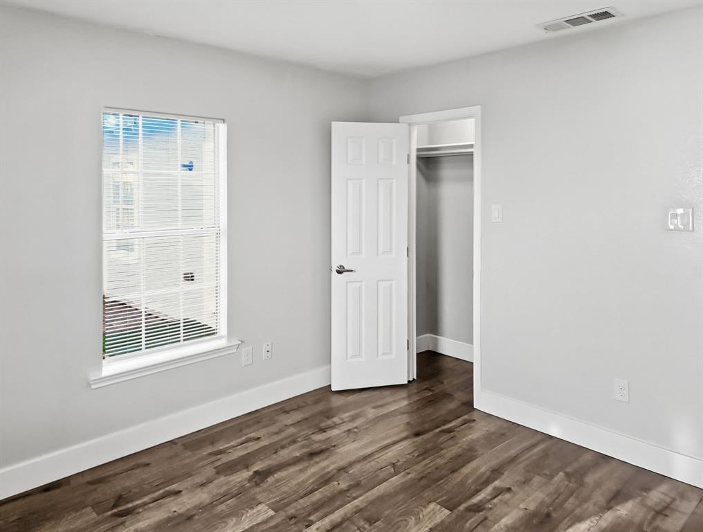 110 Ramsey Street Cleburne, TX 76031 - Photo 24 of 27 an empty room with wooden floor and windows