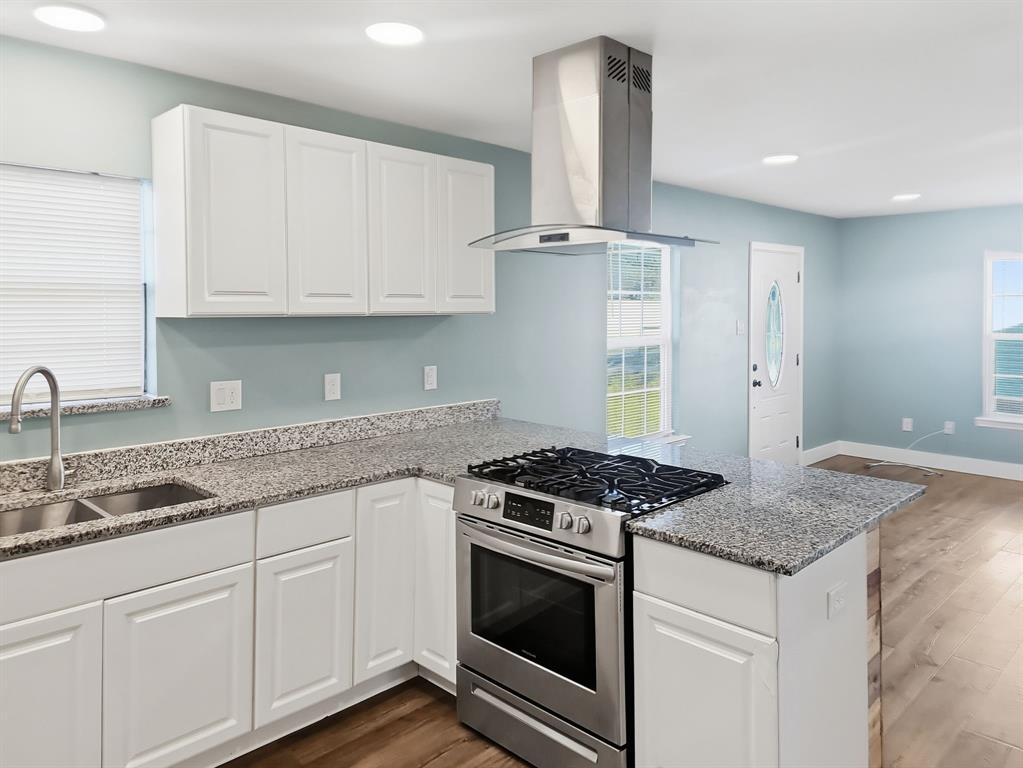 110 Ramsey Street Cleburne, TX 76031 - Photo 7 of 27 a kitchen with granite countertop a sink stove and cabinets