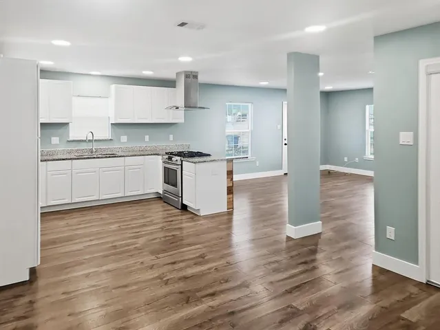 a view of an empty room with wooden floor