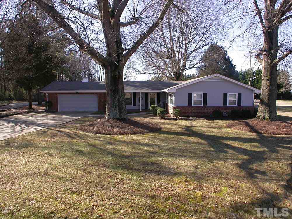 6301 Johnsdale Road Raleigh, NC 27615 - Photo 1 of 25 a front view of a house with a yard covered trees and garage
