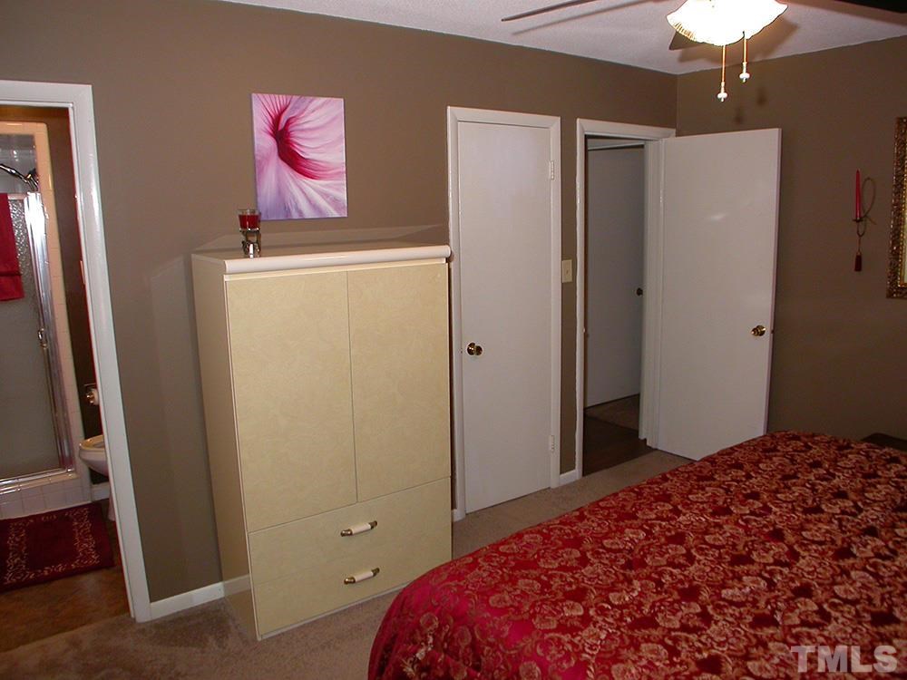 6301 Johnsdale Road Raleigh, NC 27615 - Photo 15 of 25 a bedroom with a bed and a refrigerator