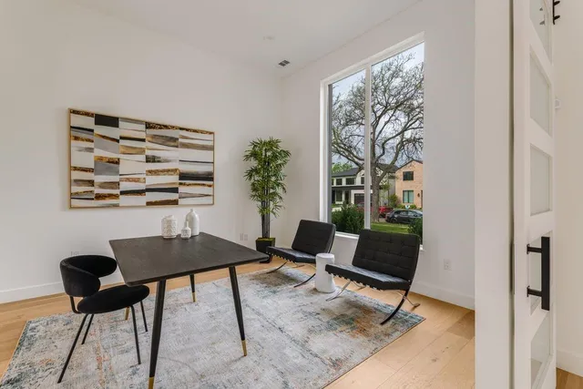 a view of a workspace with furniture and a window