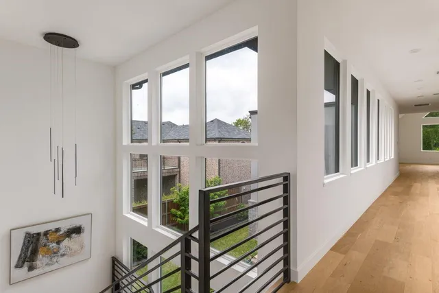 a view of a hallway with wooden floor and windows