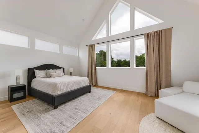 a bedroom with a large bed and a large window